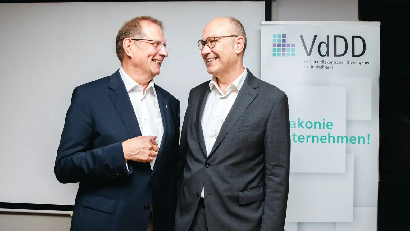 Ingo Dreyer (links) und Rüdiger Schuch (rechts) stehen sich zugewandt und lachend gegenüber.
