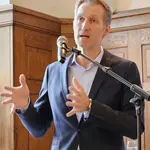 Daniel Terzenbach steht am Rednerpult, gestikuliert und spricht zu einem Publikum.