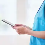 Eine Pflegerin hält ein Tablet