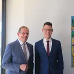 Ingo Dreyer (links) und Dr. Max Mälzer (rechts) stehen nebeneinander in einem hellen Büroraum.